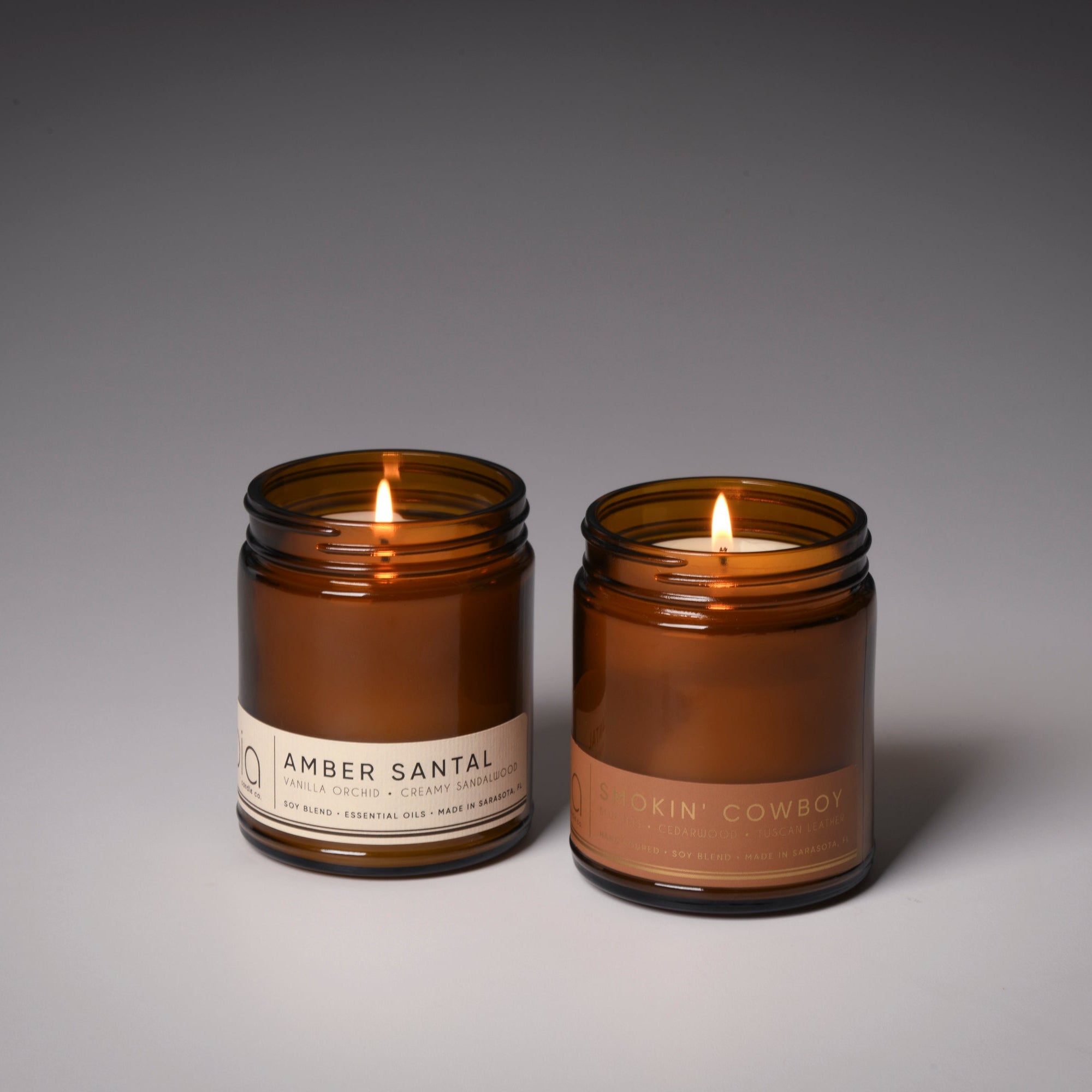 Two amber glass soy candles, Amber Santal and Smokin' Cowboy