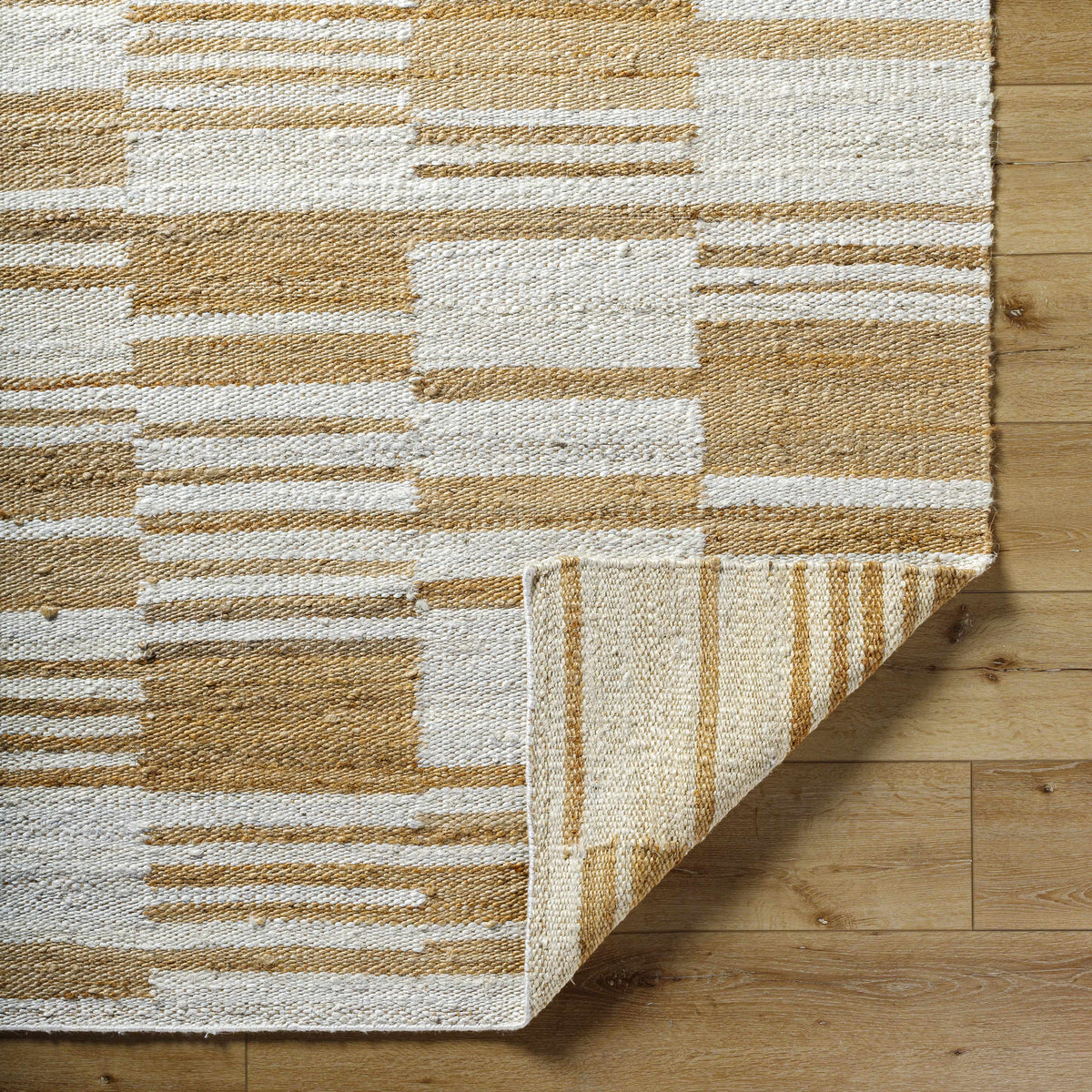 Natural jute flatweave rug in ivory and tan stripe pattern.