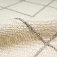 Cream wool rug with a hand-drawn gray grid pattern