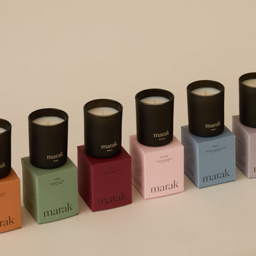 Marak scented candles in black glass votives, each in a colored box. Part of a seven-piece gift set.